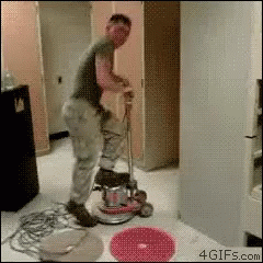 the man is using a floor buffer machine to remove a hole