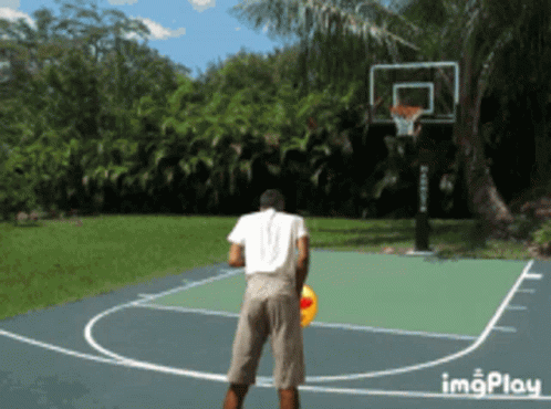 a man standing on a basketball court near a basketball net