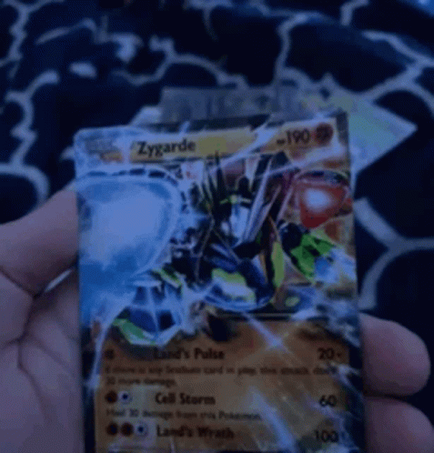 a person holding up a pokemon card with an evil dragon on it