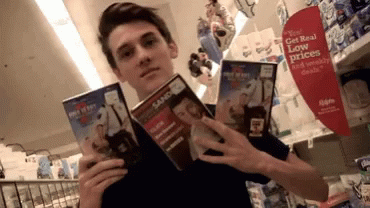 a person holds up some books in a store