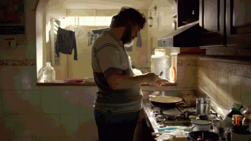 a man in an empty kitchen preparing food