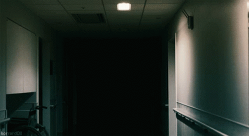 a dimly lit hallway leading to a door