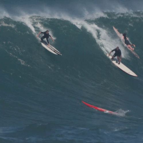 three people surfing in the ocean on surfboards
