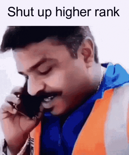 a man talking on a cell phone while wearing a vest