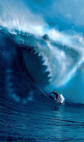 a man on a surfboard riding a huge wave