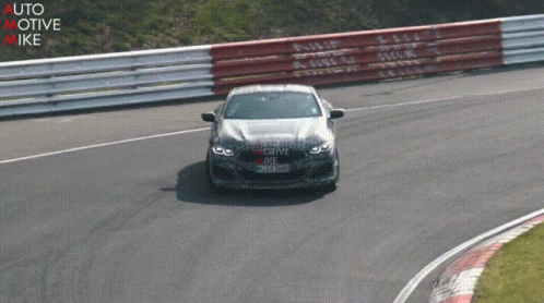 a bmw car driving around a corner on a race track