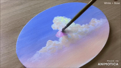 the artist draws pink clouds on the paper to make a painting