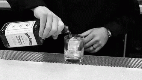 the bartender is pouring the drink into his glass