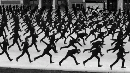 a large group of men running down a snowy surface