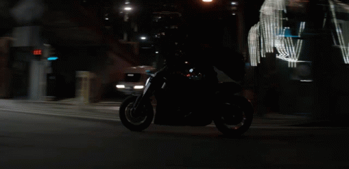 the motorcyclist is going down the road at night