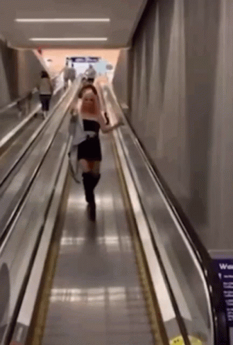 people are moving down an escalator at a subway
