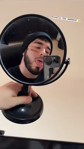 man reflected in mirror while making a funny face