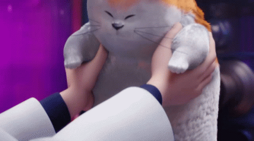 a stuffed cat is held up by its handler