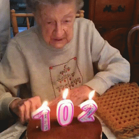 an old woman with a candle lit in the shape of a number