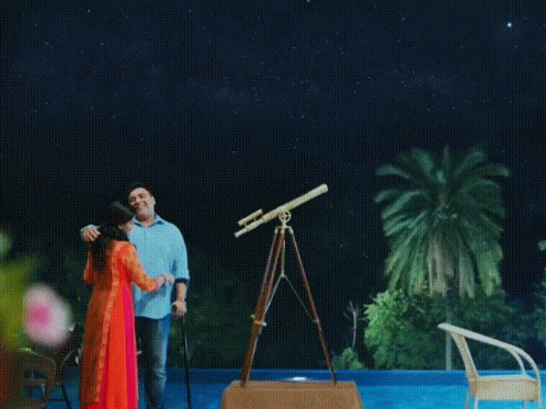 the couple is standing under a stargazed sky