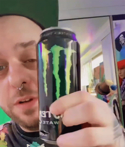 a guy has an energy drink with the monster logo