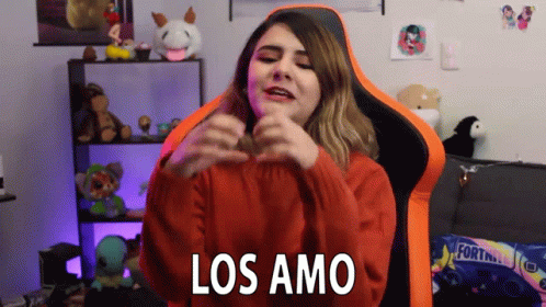 a girl dressed in a dark room and a purple hat with the words los amos over her mouth