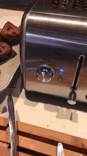a bowl with blue muffins and a silver toaster