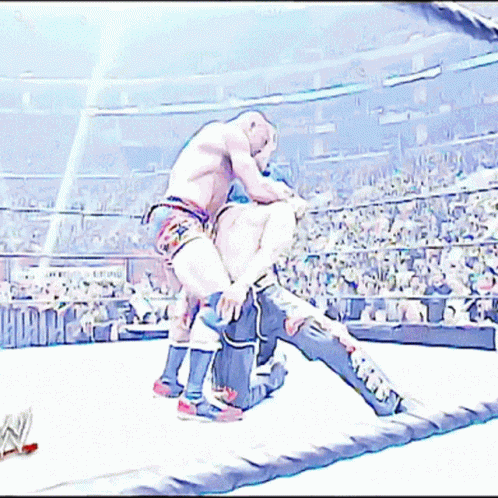 two wrestlers are wrestling on the ring