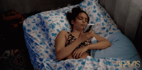 a woman in a bed with an electronic device