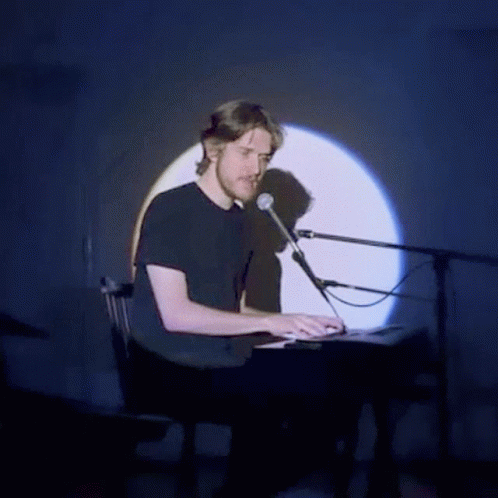 a man in black shirt and headphones playing a keyboard