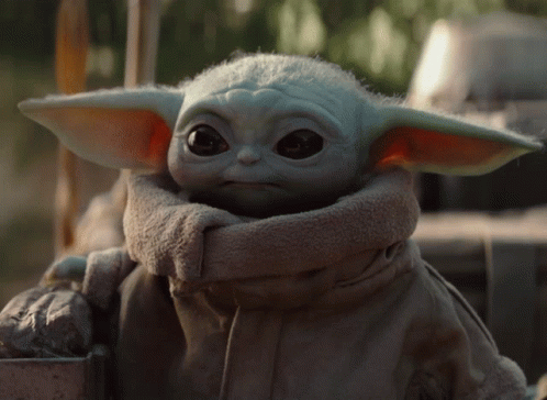 a baby yoda wearing a robe and carrying a box