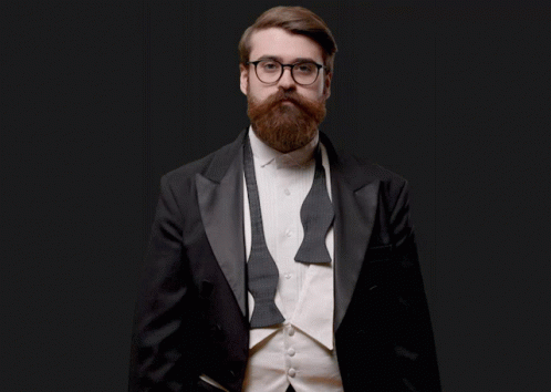a bearded man with glasses, beard and a suit jacket