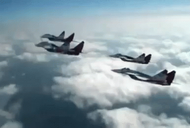 four jets flying in formation across the clouds