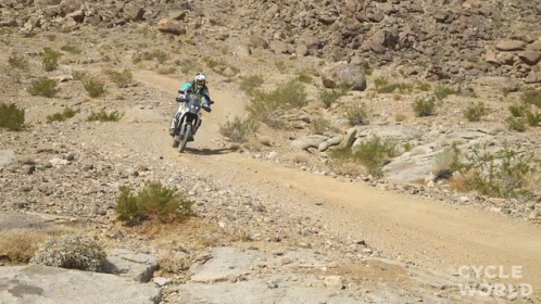 a man riding a dirt bike on a dirt path