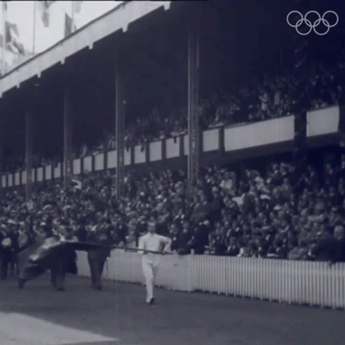 a vintage po shows spectators in the stands with some horses