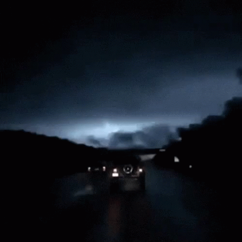 dark and cloudy night clouds above road cars