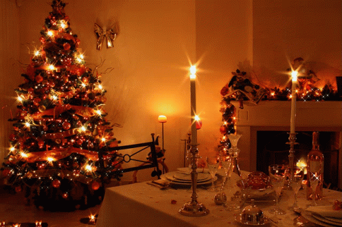 the christmas tree is surrounded by candles and plates