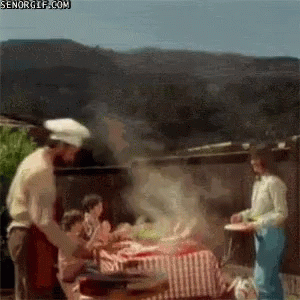 some chefs are standing near a grill and cooking
