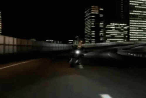 a man riding a motorcycle down a street at night