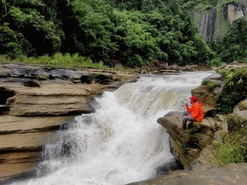 a person standing on the edge of a waterfall