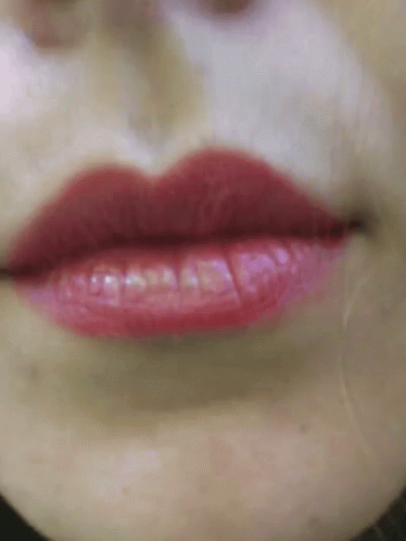 a close up view of a face with purple lipstick