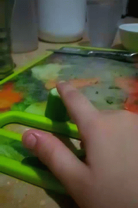 someones hand with scissors painting soing blue and green