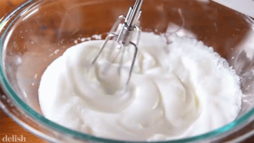 whipped cream has been whisked into a blue bowl