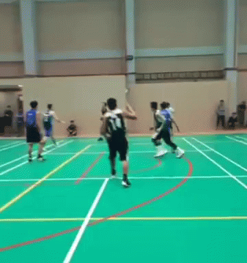 a group of young men playing frisbee in a gymnasium