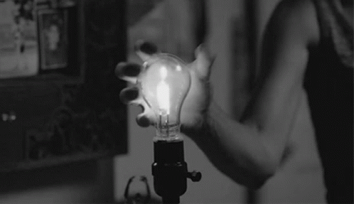 a black and white po with a light bulb being held by someone