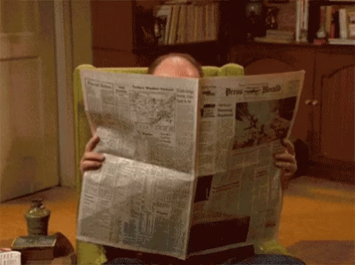 a blue gloved hand that is looking at newspaper