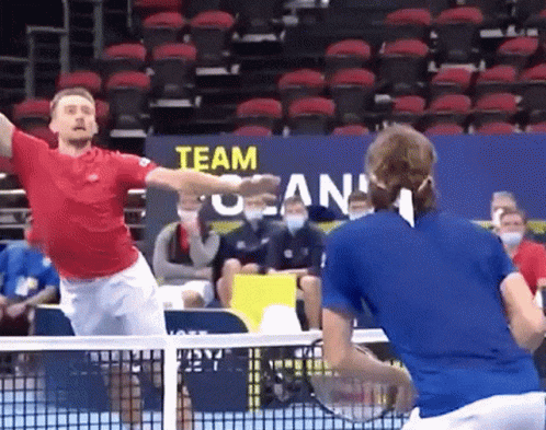 two men play tennis on an arena court
