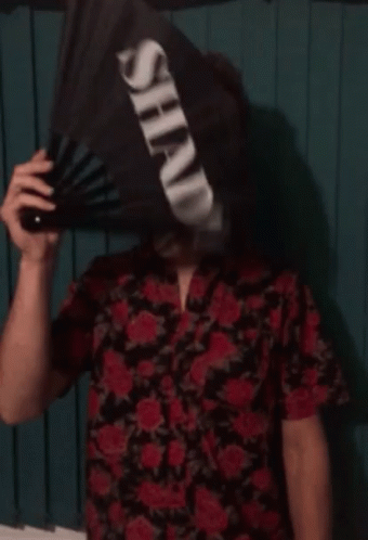 a person is wearing a strange hat and holding a fan