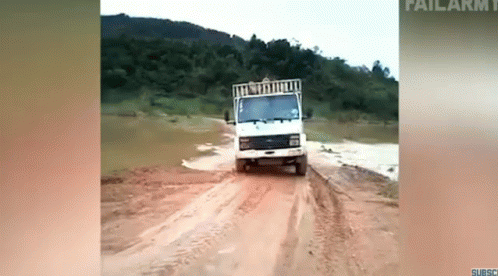 a truck is driving down a dirt road