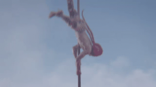 a silhouette of a person doing aerial acrobatics on a metal pole