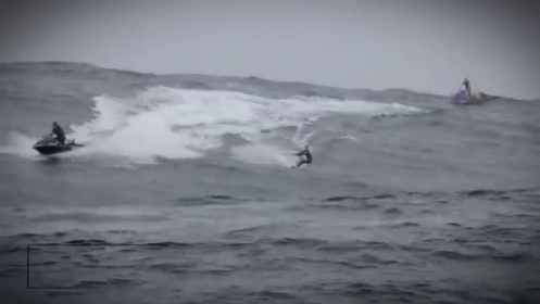 a couple of men are surfing in the ocean