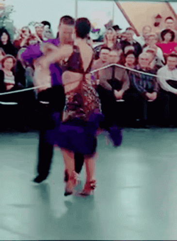two people dancing while a crowd watches
