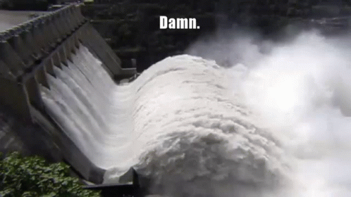 water gushes out from a dam and falls onto a river