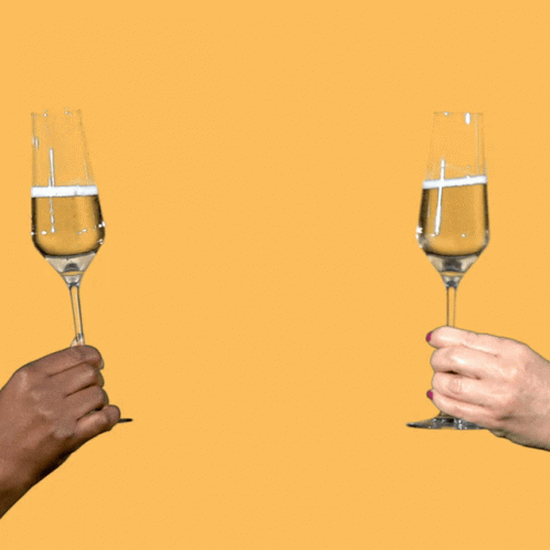 two persons holding champagne glasses with blue liquid