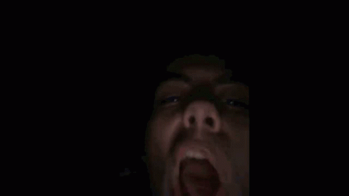 a lit up screaming face with his mouth open